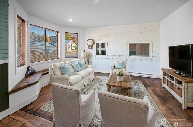 living room with baseboard heating and wood finished floors