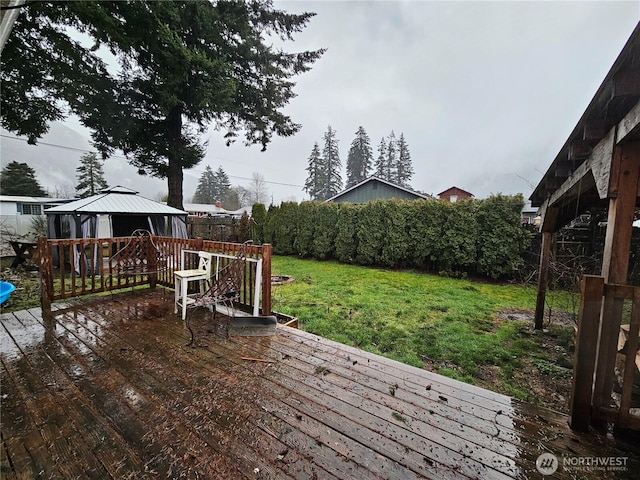 wooden deck featuring a lawn and a gazebo