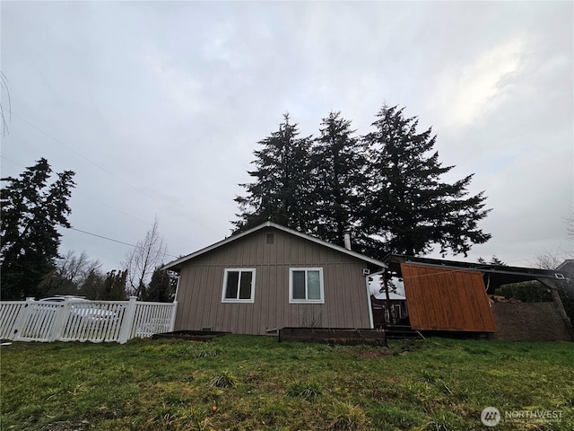 view of property exterior with a yard and fence