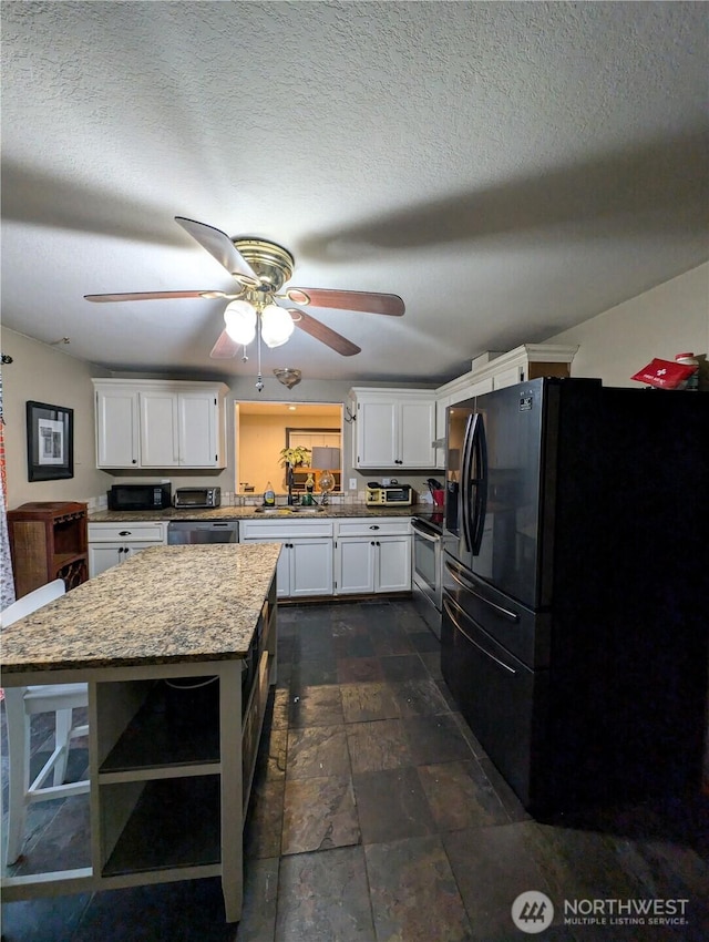 kitchen featuring a ceiling fan, white cabinets, freestanding refrigerator, a center island, and open shelves