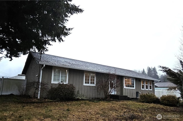 single story home with board and batten siding and fence