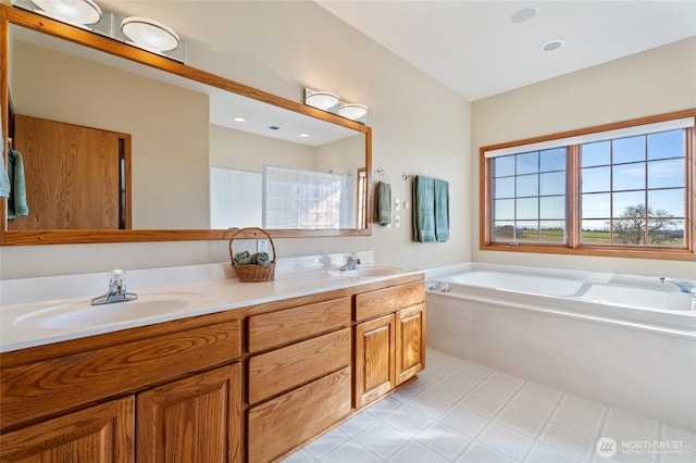 bathroom featuring a bath, double vanity, and a sink