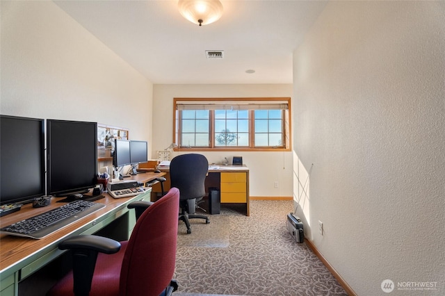 carpeted office with visible vents and baseboards