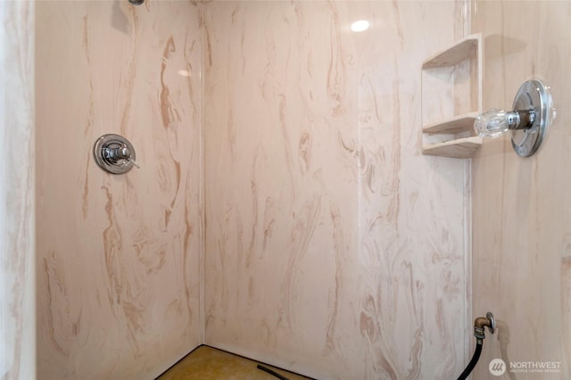 interior details featuring a marble finish shower