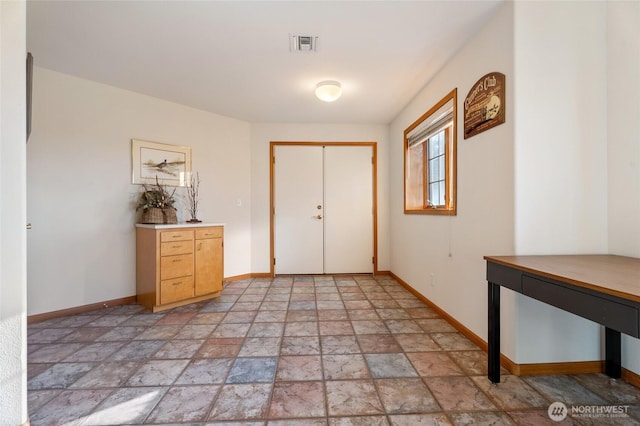 entrance foyer with visible vents, baseboards, and stone tile flooring