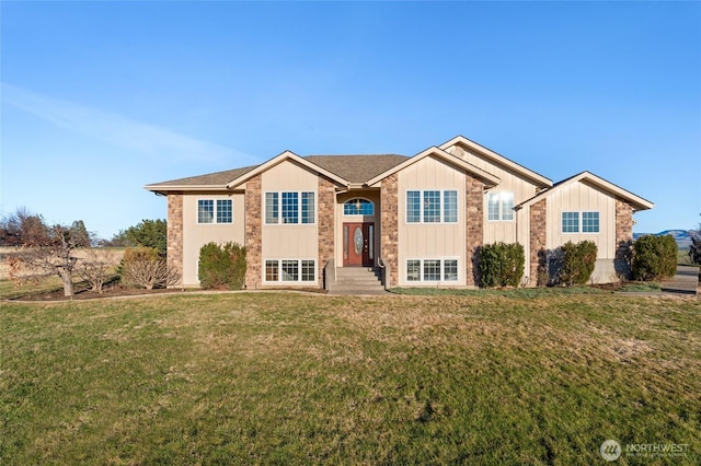 bi-level home featuring board and batten siding and a front yard