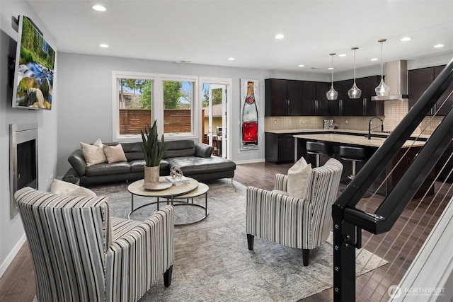 living area featuring dark wood-style floors, recessed lighting, a fireplace, and baseboards