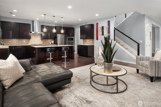 living area with recessed lighting, dark wood-style flooring, baseboards, and stairs