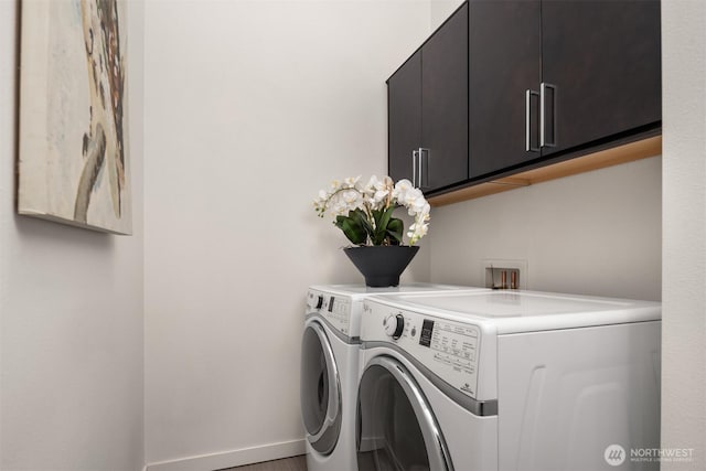 clothes washing area with separate washer and dryer, cabinet space, and baseboards