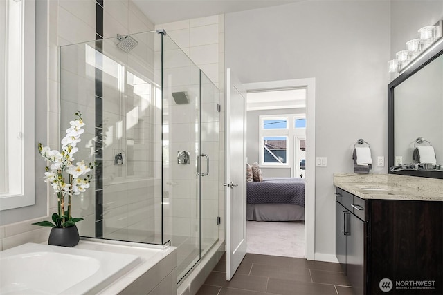 ensuite bathroom with a bath, tile patterned flooring, a shower stall, vanity, and baseboards