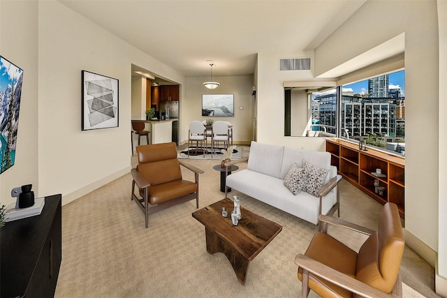 2821 2nd Ave Unit 1005, Seattle, WA 98121 - living room featuring light carpet, a city view, visible vents, and baseboards