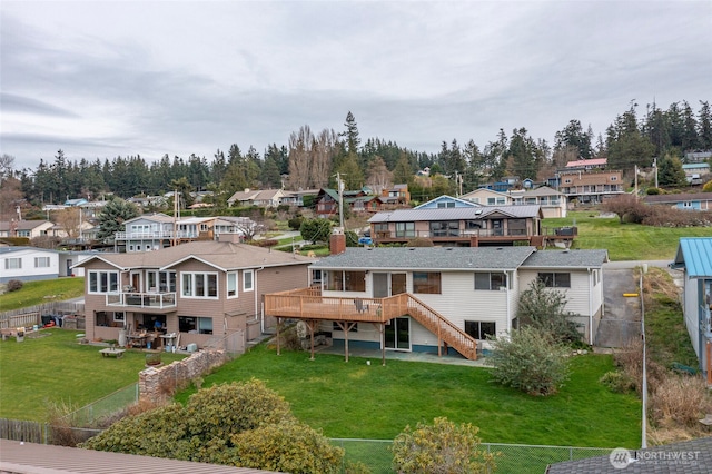 rear view of house featuring a residential view, stairs, and a yard