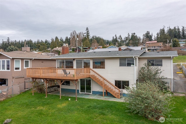 rear view of property with a patio, fence, a wooden deck, a yard, and stairs