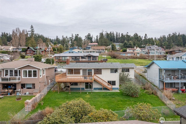 back of property with a residential view, stairway, and a yard