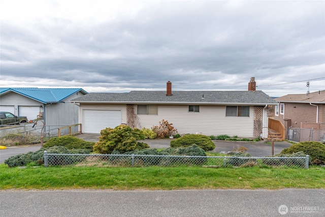 ranch-style house with a chimney, fence private yard, and an attached garage