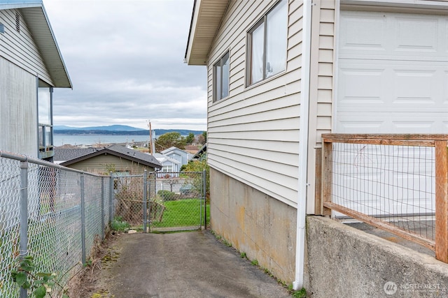 view of side of home featuring a gate, fence, and a mountain view