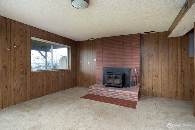 unfurnished living room featuring carpet floors and wood walls