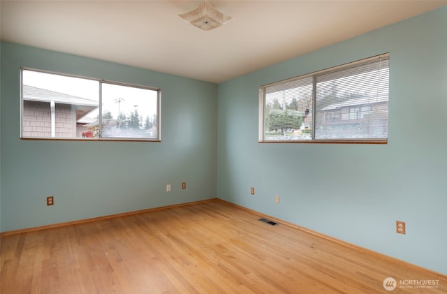 spare room featuring visible vents and wood finished floors