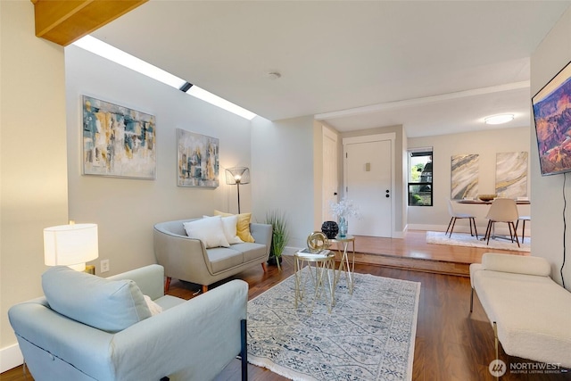 living area featuring dark wood-style flooring and baseboards