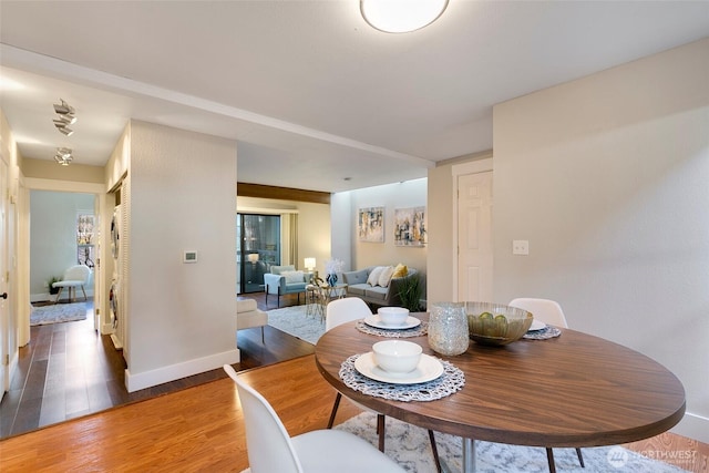 dining space featuring baseboards and wood finished floors