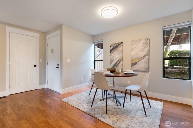 dining area with baseboards and wood finished floors