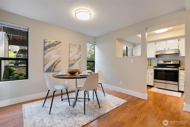 dining room with light wood-style flooring and baseboards