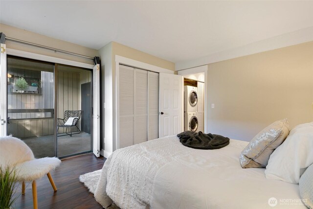 bedroom featuring stacked washer / dryer, wood finished floors, and access to exterior