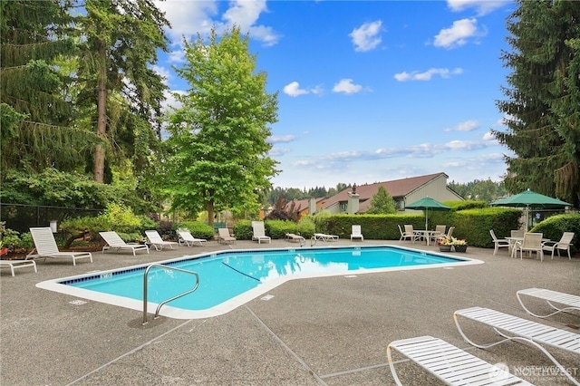 community pool with fence and a patio