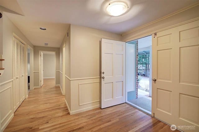 foyer entrance with light wood-style flooring and baseboards