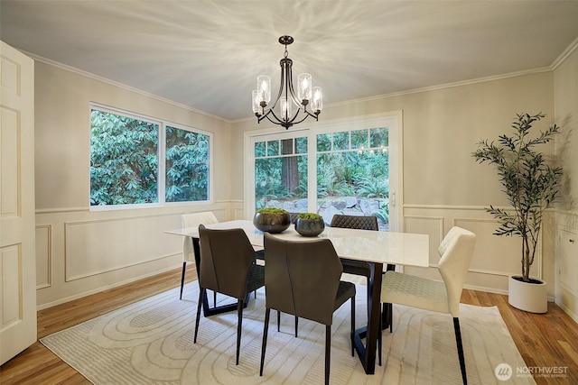 dining area with a chandelier, plenty of natural light, and crown molding