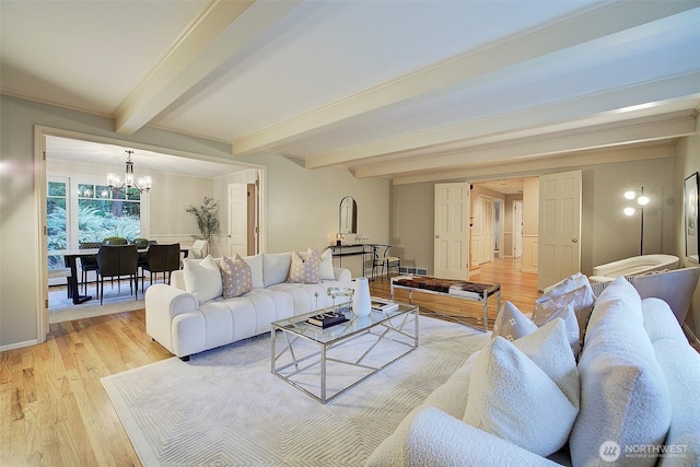 living area with a chandelier, light wood finished floors, beam ceiling, and baseboards