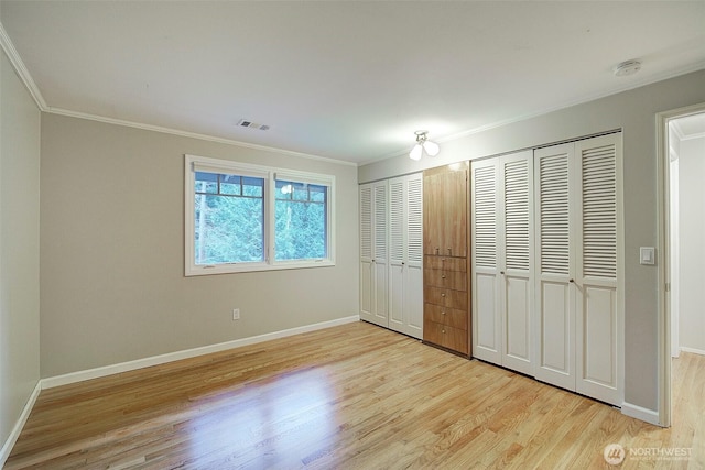 unfurnished bedroom with ornamental molding, light wood finished floors, visible vents, and baseboards