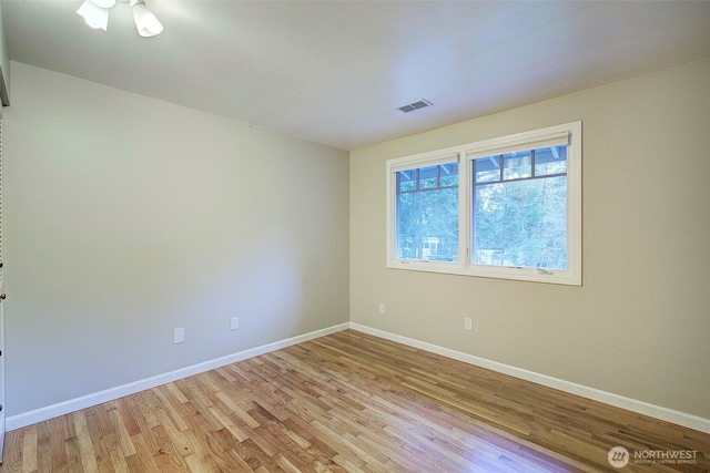 unfurnished room with light wood finished floors, baseboards, and visible vents