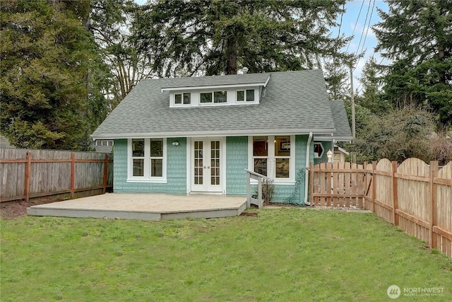 back of house featuring french doors, a yard, a fenced backyard, and a shingled roof