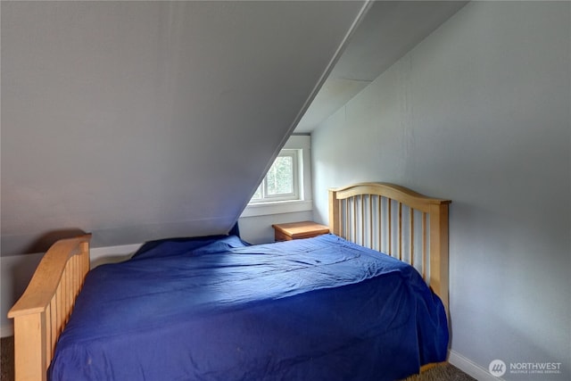 bedroom with vaulted ceiling, carpet, and baseboards