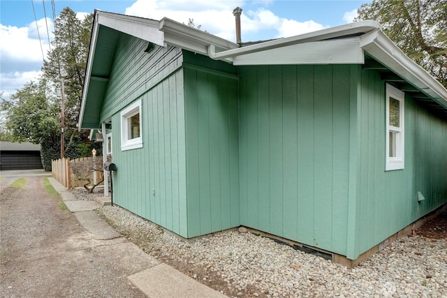 view of property exterior featuring fence and a garage