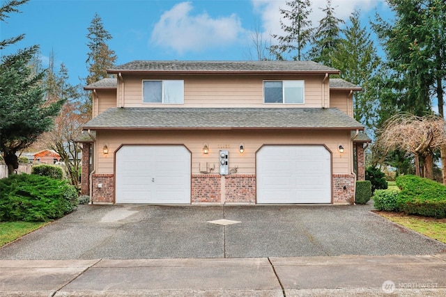 view of front of home with aphalt driveway, brick siding, and an attached garage