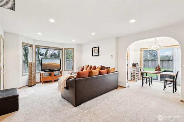 living room with arched walkways, a chandelier, recessed lighting, light colored carpet, and visible vents