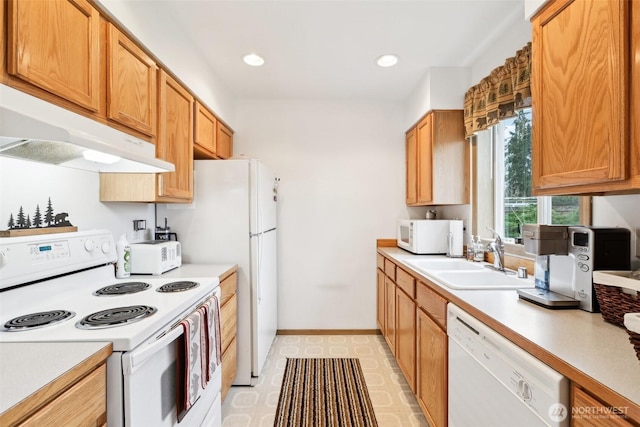 kitchen featuring white appliances, under cabinet range hood, light countertops, and a sink