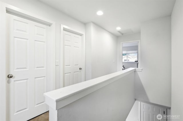 hallway with recessed lighting, attic access, and an upstairs landing