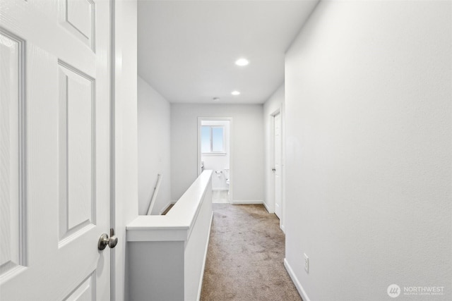 hall featuring recessed lighting, baseboards, light colored carpet, and an upstairs landing