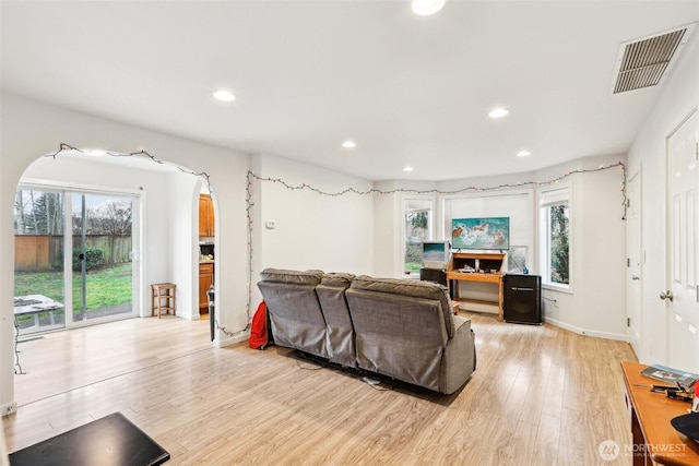 living room featuring light wood-style flooring, plenty of natural light, visible vents, and recessed lighting