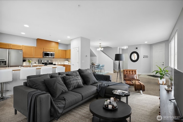 carpeted living area featuring a chandelier, baseboards, and recessed lighting