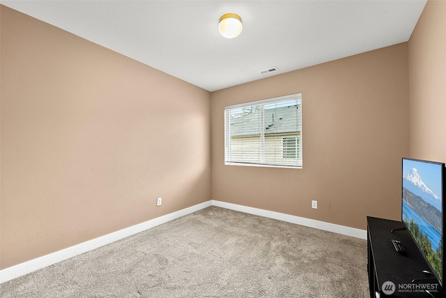 empty room with carpet, visible vents, and baseboards