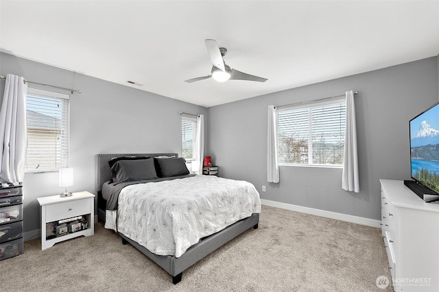 bedroom with light carpet, multiple windows, visible vents, and baseboards