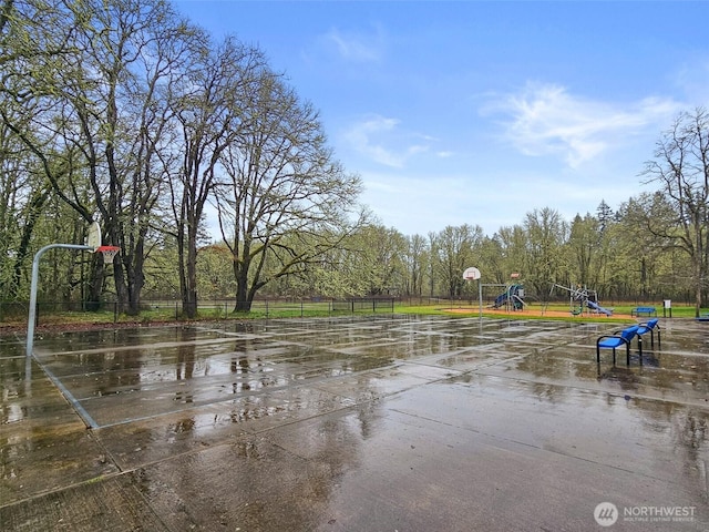 view of sport court with playground community, community basketball court, and fence