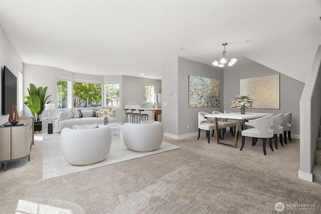 carpeted living room featuring plenty of natural light, baseboards, and a chandelier