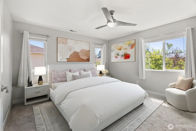 carpeted bedroom with ceiling fan, baseboards, and visible vents