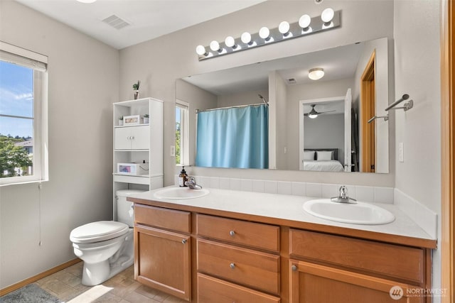 ensuite bathroom with double vanity, visible vents, toilet, and a sink