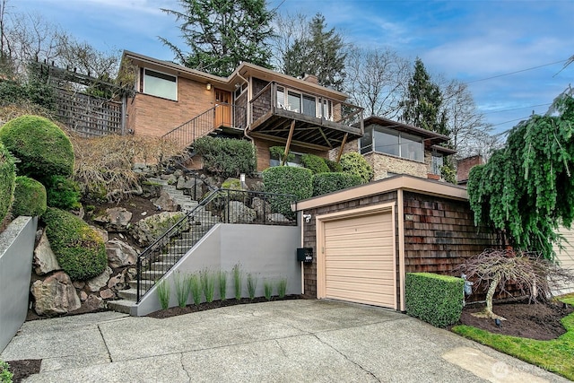 view of front of home featuring a garage, concrete driveway, and stairs